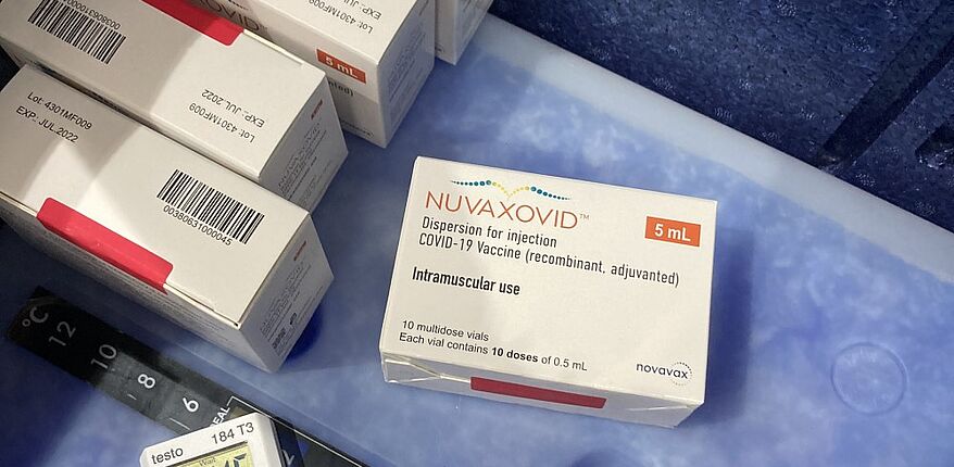 Das Foto zeigt ein Motiv auf die Schachteln, in denen der Impfstoff Nuvaxodid von Novavax verpackt ist. Die Packungen liegen in einer Box, die Temperatur wir duch ein inneliegendes Thermometer überwacht. 